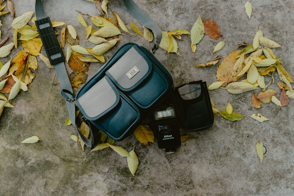 Une sacoche photo, un flash Nikon et un étui à filtres