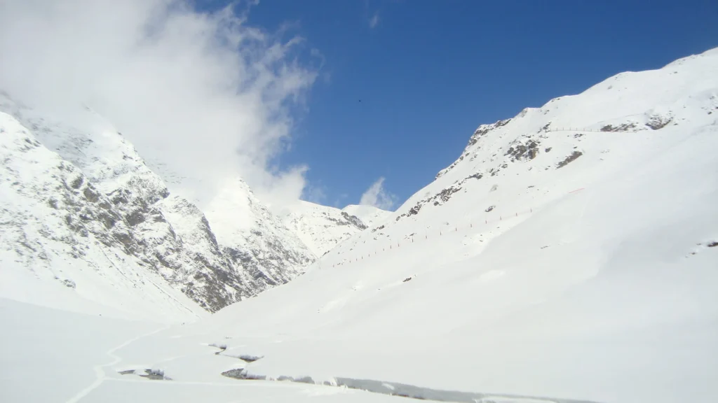 Une ligne de crête sur ciel bleu profond au-dessus d’une pente enneigée