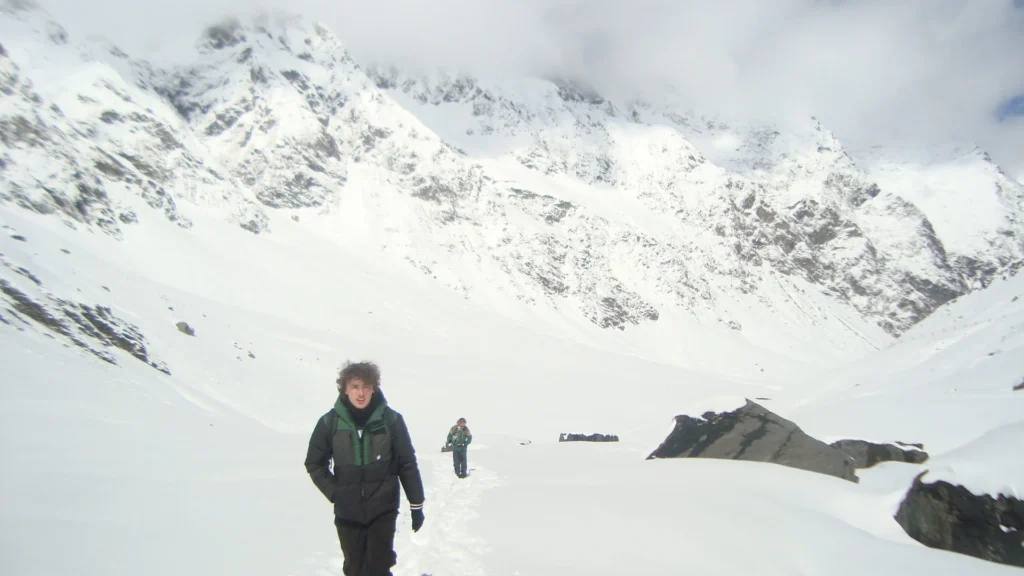 Deux randonneurs dans la neige, rochers affleurant au second plan
