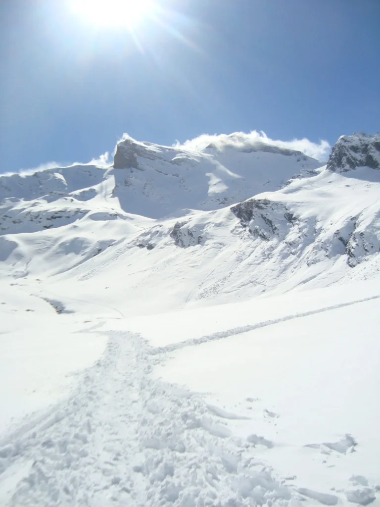 Un cirque enneigé traversé par une trace de passage
