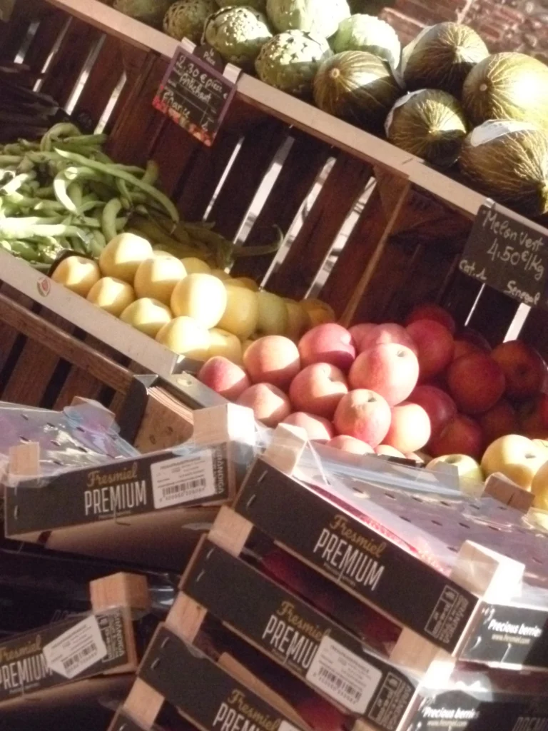 Un étal de fruits, pommes et poires, avec une ardoise de prix