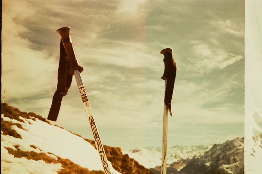 Deux paires de skis plantées dans la neige, gants posés sur les bâtons