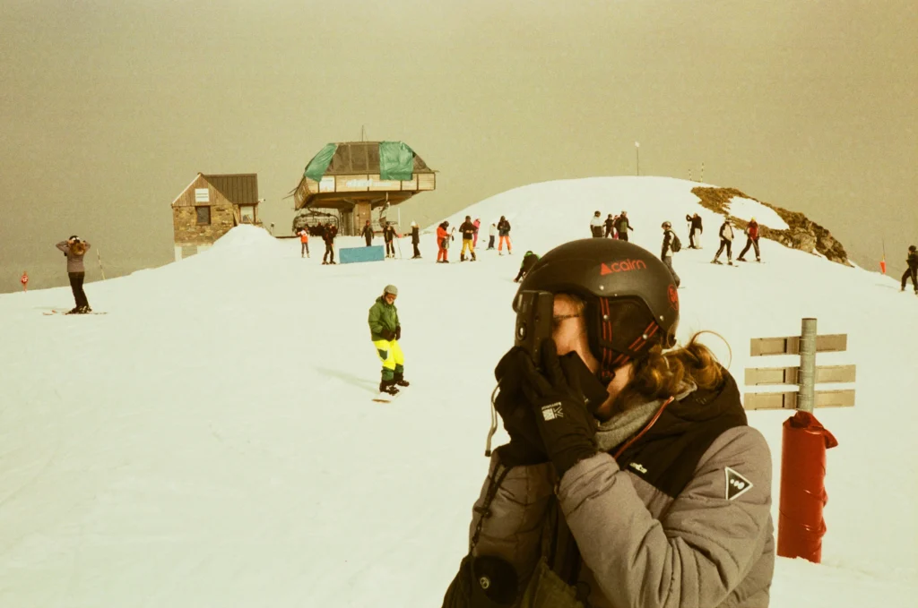 Un bâtiment d’altitude au sommet d’une piste, skieurs alentour
