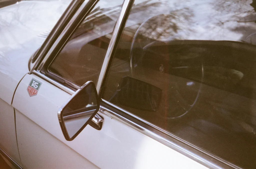 Rétroviseur chromé et pare-brise d’une voiture blanche