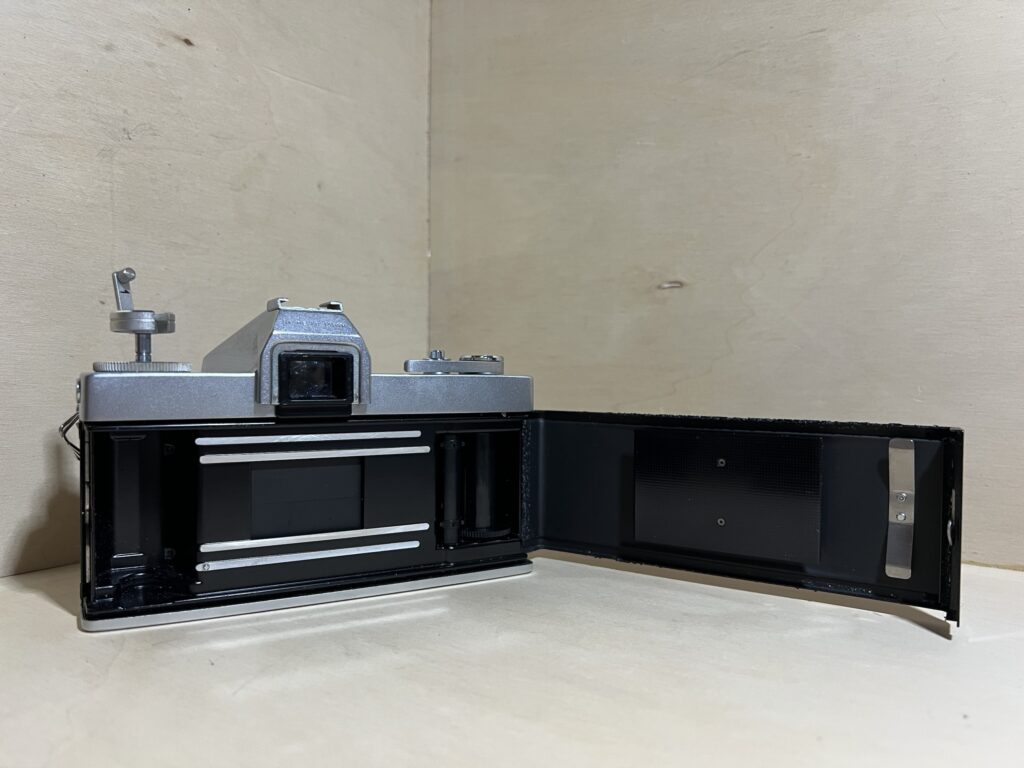 Reflex argentique ouvert à l'atelier, dos déployé : les gorges qui reçoivent les mousses d'étanchéité courent le long de la porte