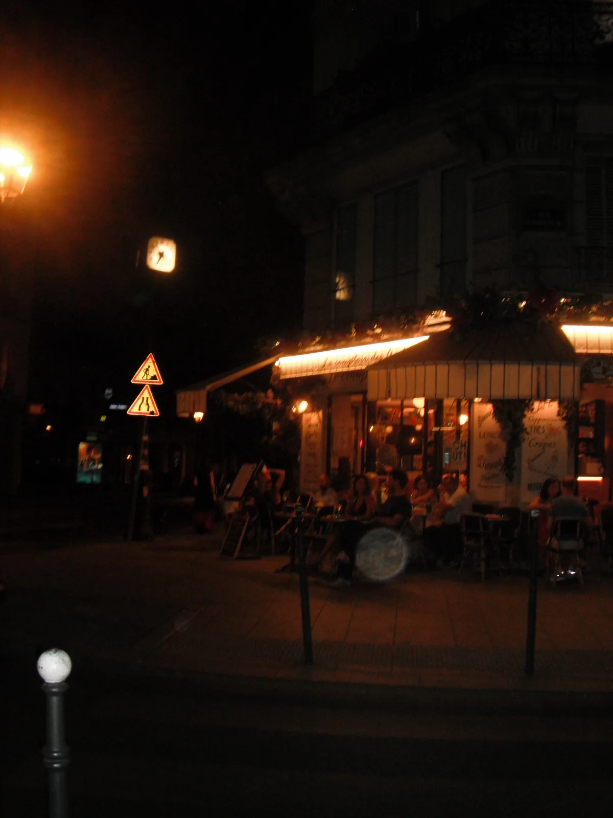 Coin de rue parisien la nuit, terrasse éclairée et lampadaire, au Fujifilm FinePix XP15