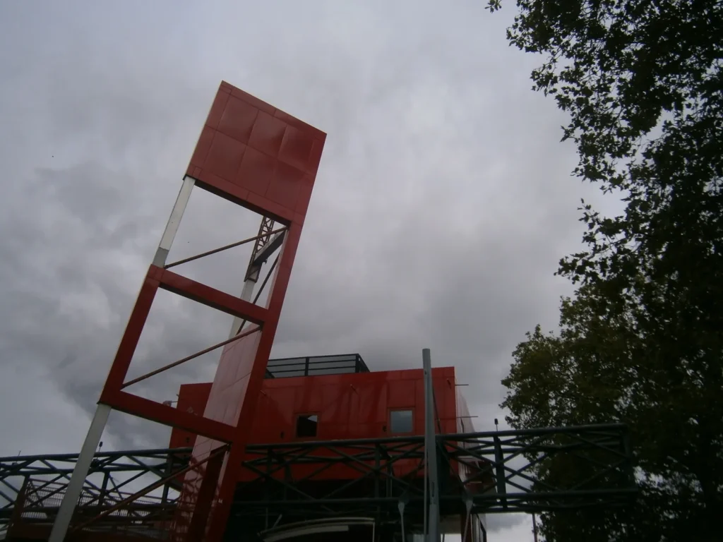 Folie rouge de Bernard Tschumi au parc de la Villette sous un ciel chargé, photo Olympus VG-120