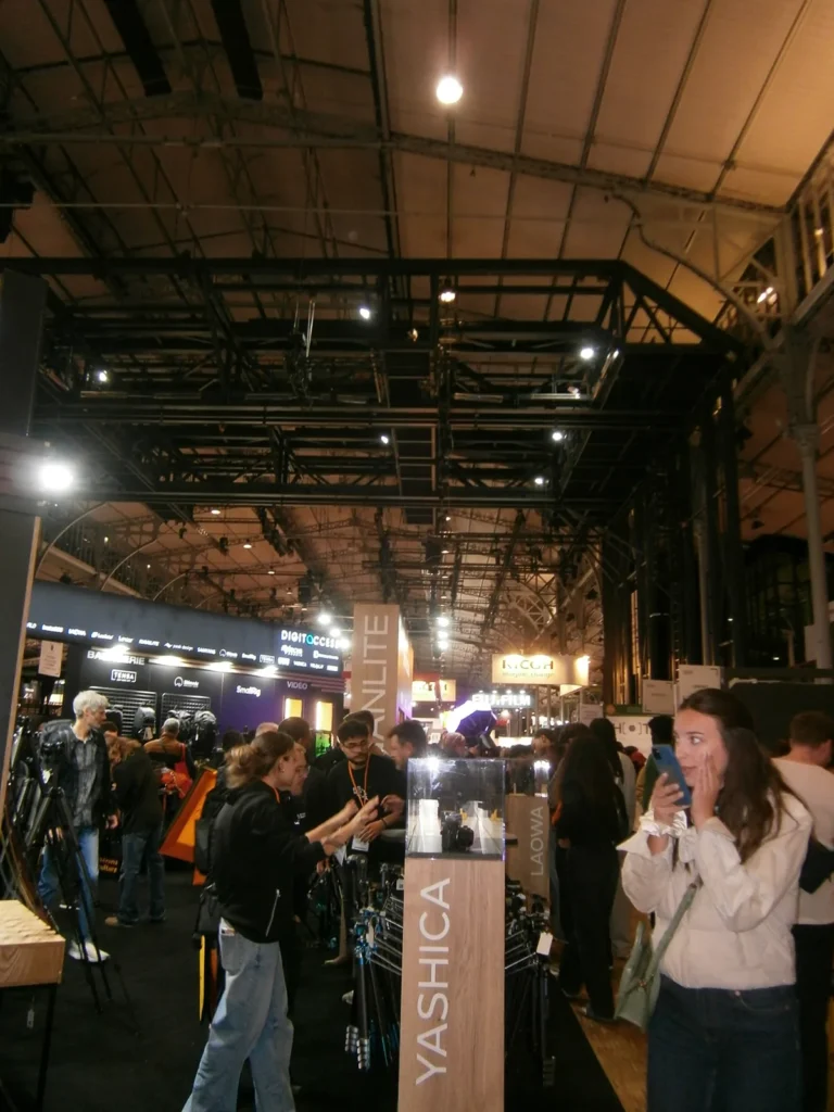 Allée du Salon Photo & Vidéo 2026 devant le stand Yashica, photo Olympus VG-120 au flash