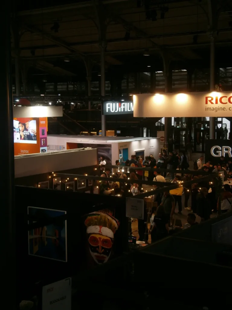 Foule entre les stands Fujifilm et Ricoh du Salon Photo & Vidéo 2026, photo Olympus VG-120